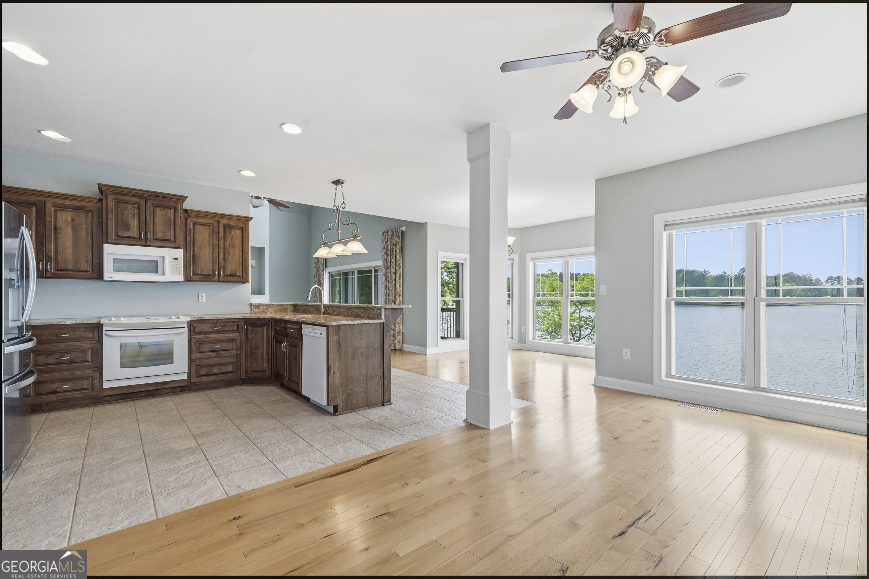 1038 Dennis Station Road Southwest Eatonton, GA 31024 - Photo 31 of 72 a large kitchen with stainless steel appliances a large counter top a stove a chimney a sink and large window