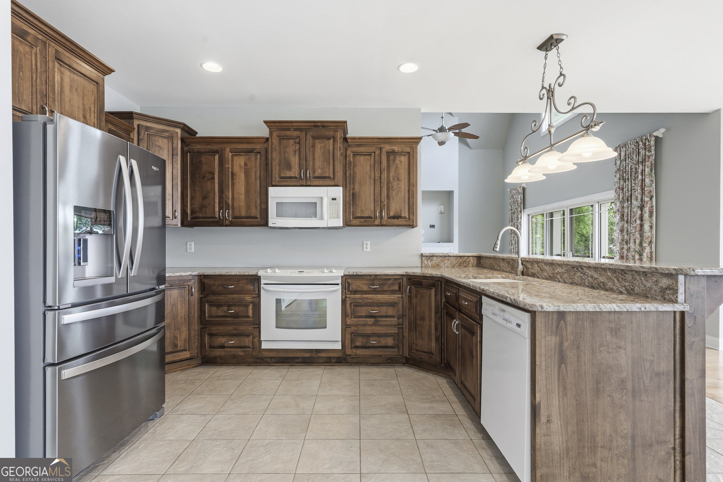1038 Dennis Station Road Southwest Eatonton, GA 31024 - Photo 32 of 72 a kitchen with stainless steel appliances granite countertop a refrigerator a stove and a sink