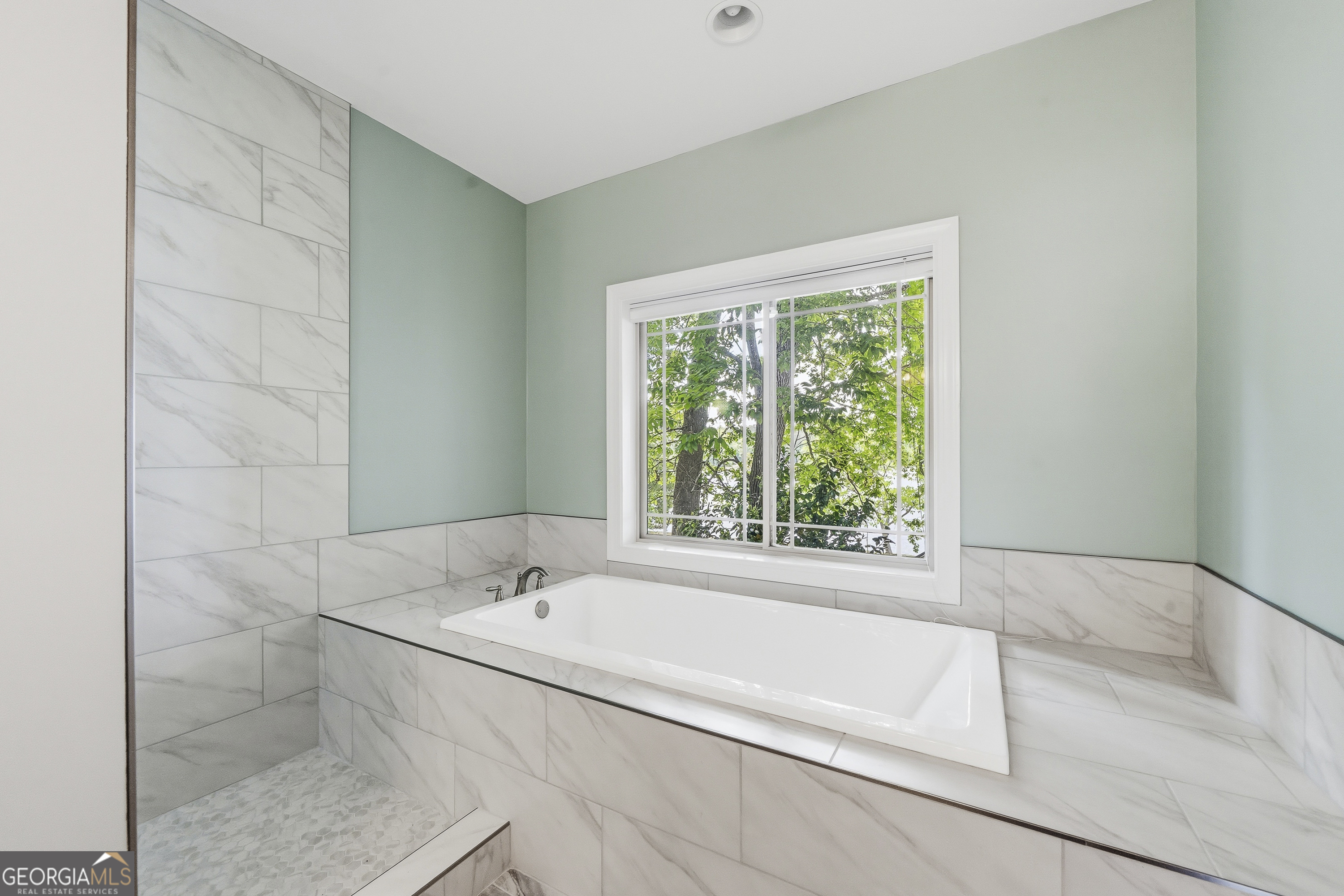 1038 Dennis Station Road Southwest Eatonton, GA 31024 - Photo 43 of 72 a white bath tub sitting in a bathroom next to a window