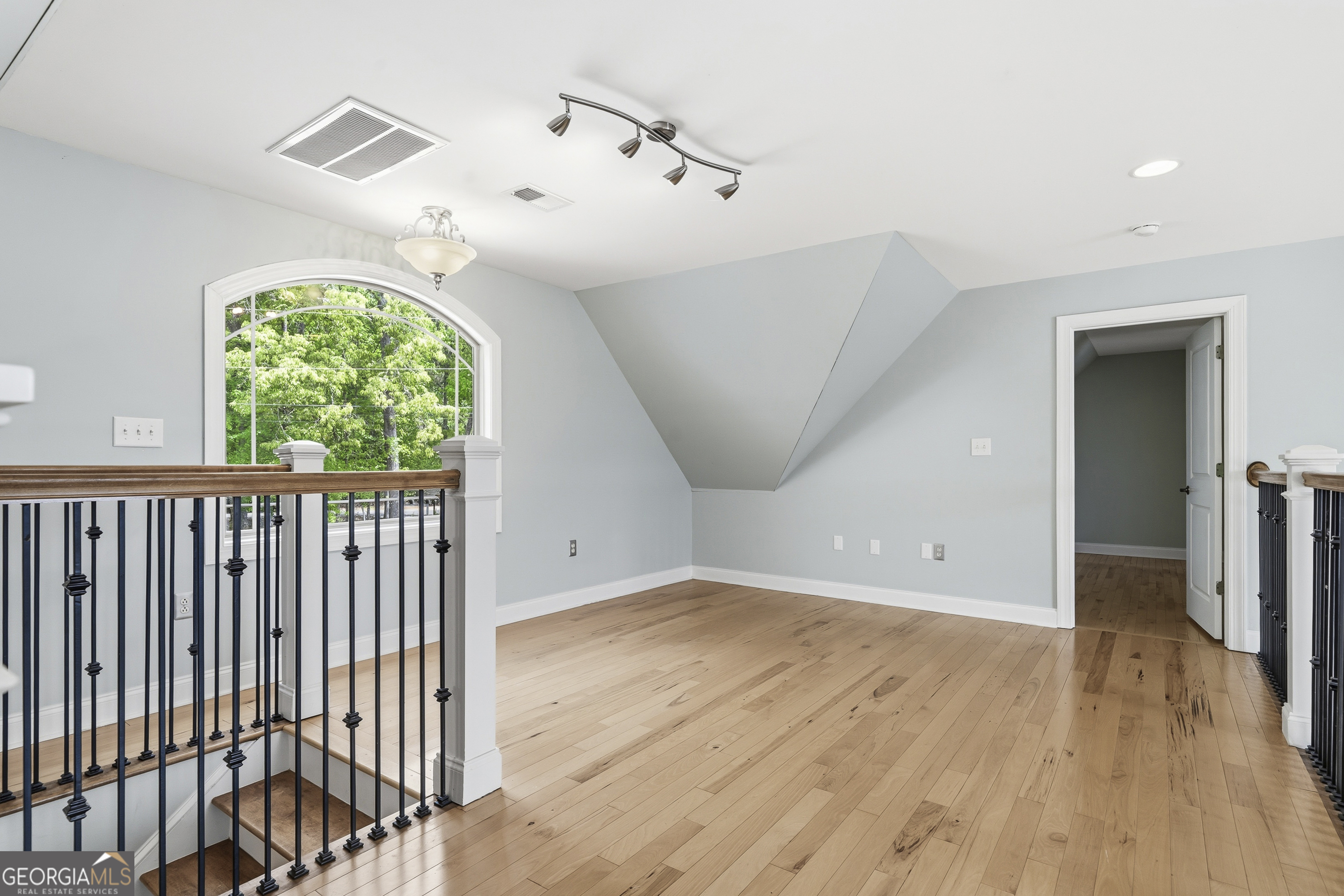 1038 Dennis Station Road Southwest Eatonton, GA 31024 - Photo 47 of 72 an empty room with wooden floor fan and windows