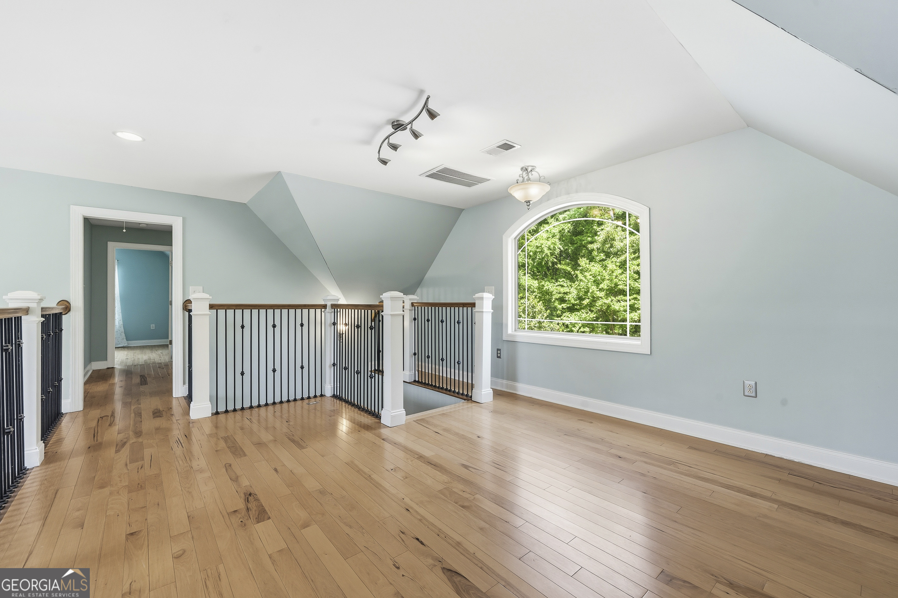 1038 Dennis Station Road Southwest Eatonton, GA 31024 - Photo 49 of 72 an empty room with wooden floor chandelier and windows