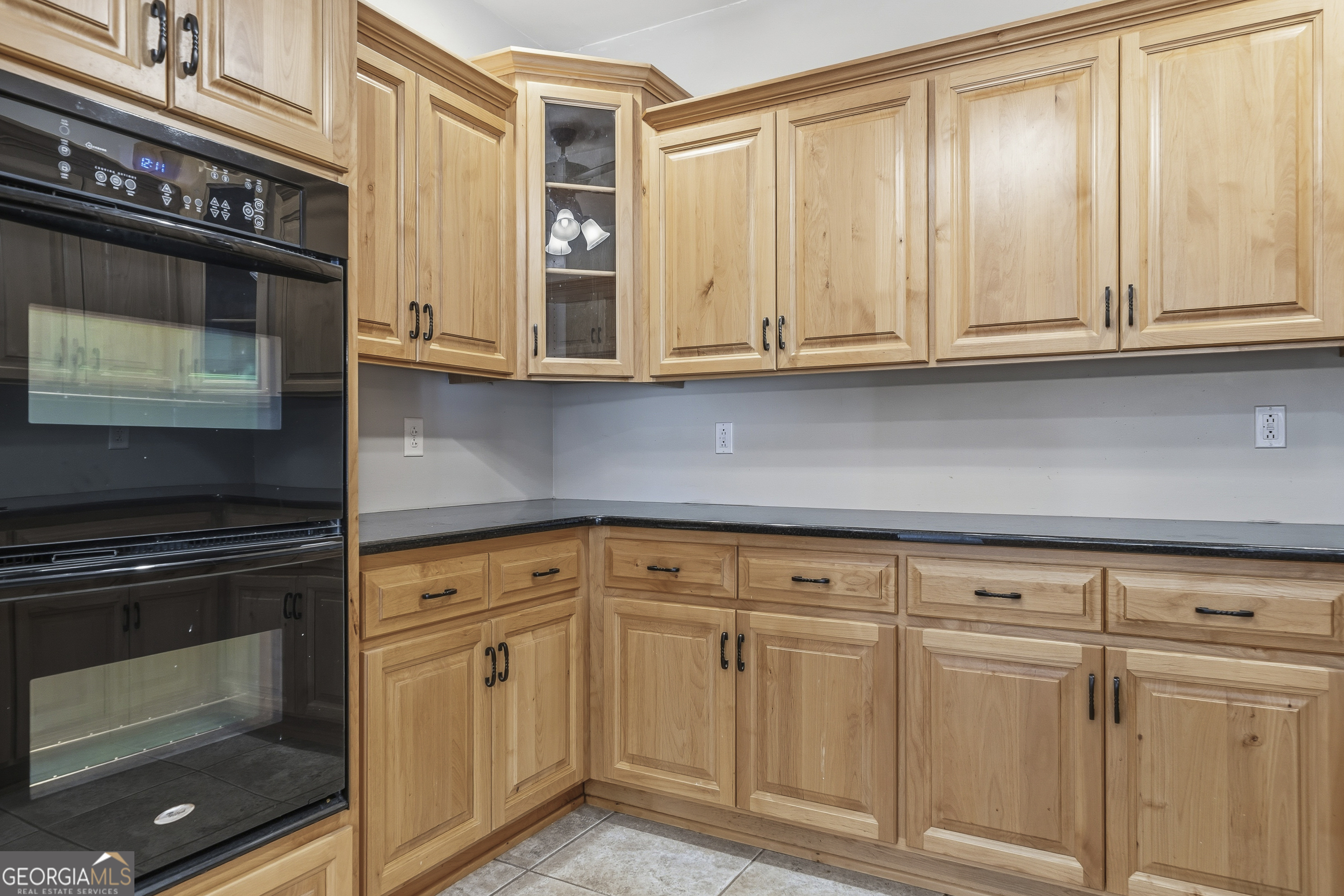 1038 Dennis Station Road Southwest Eatonton, GA 31024 - Photo 64 of 72 a kitchen with granite countertop white cabinets and stainless steel appliances