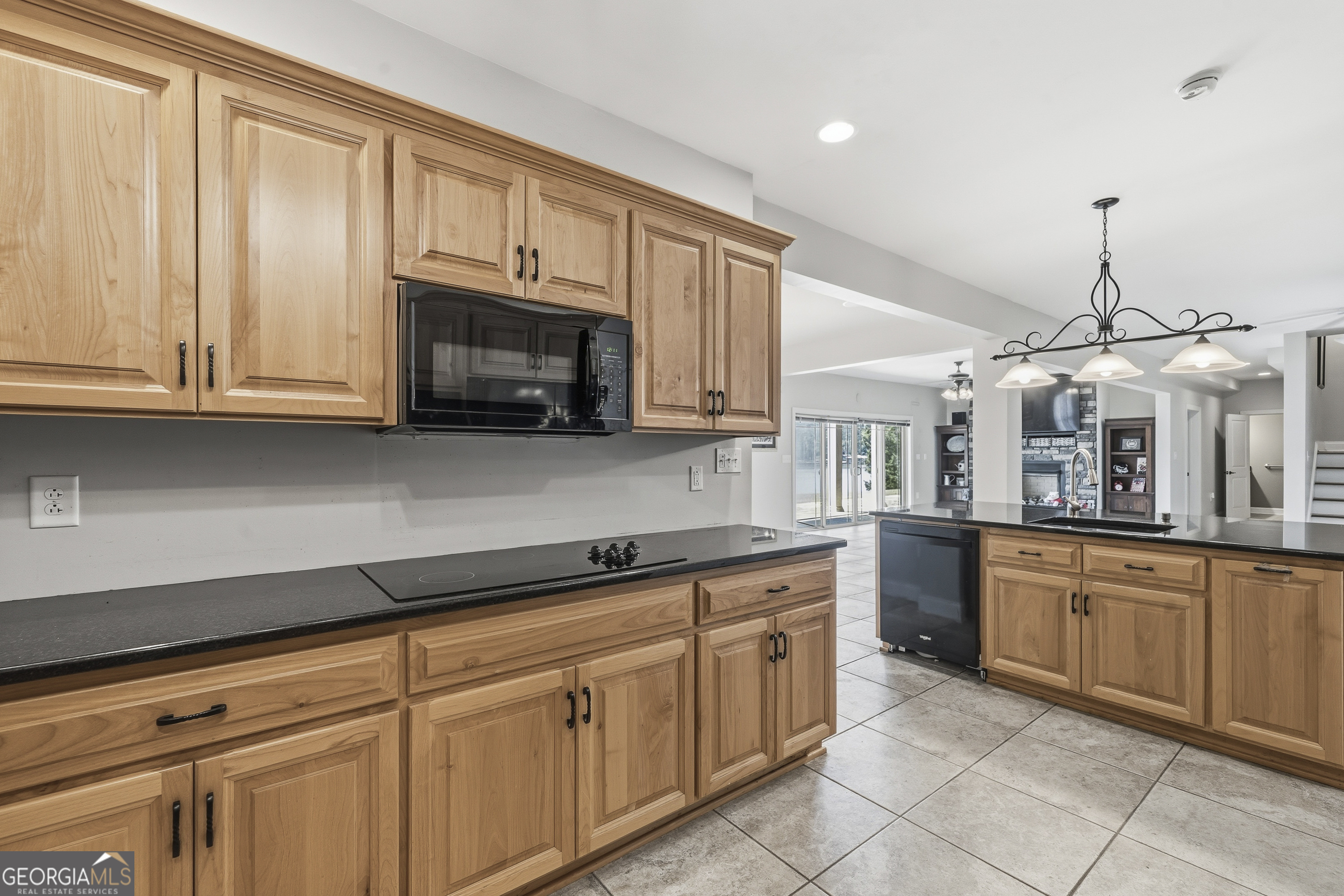 1038 Dennis Station Road Southwest Eatonton, GA 31024 - Photo 65 of 72 a kitchen with granite countertop a stove microwave and cabinets