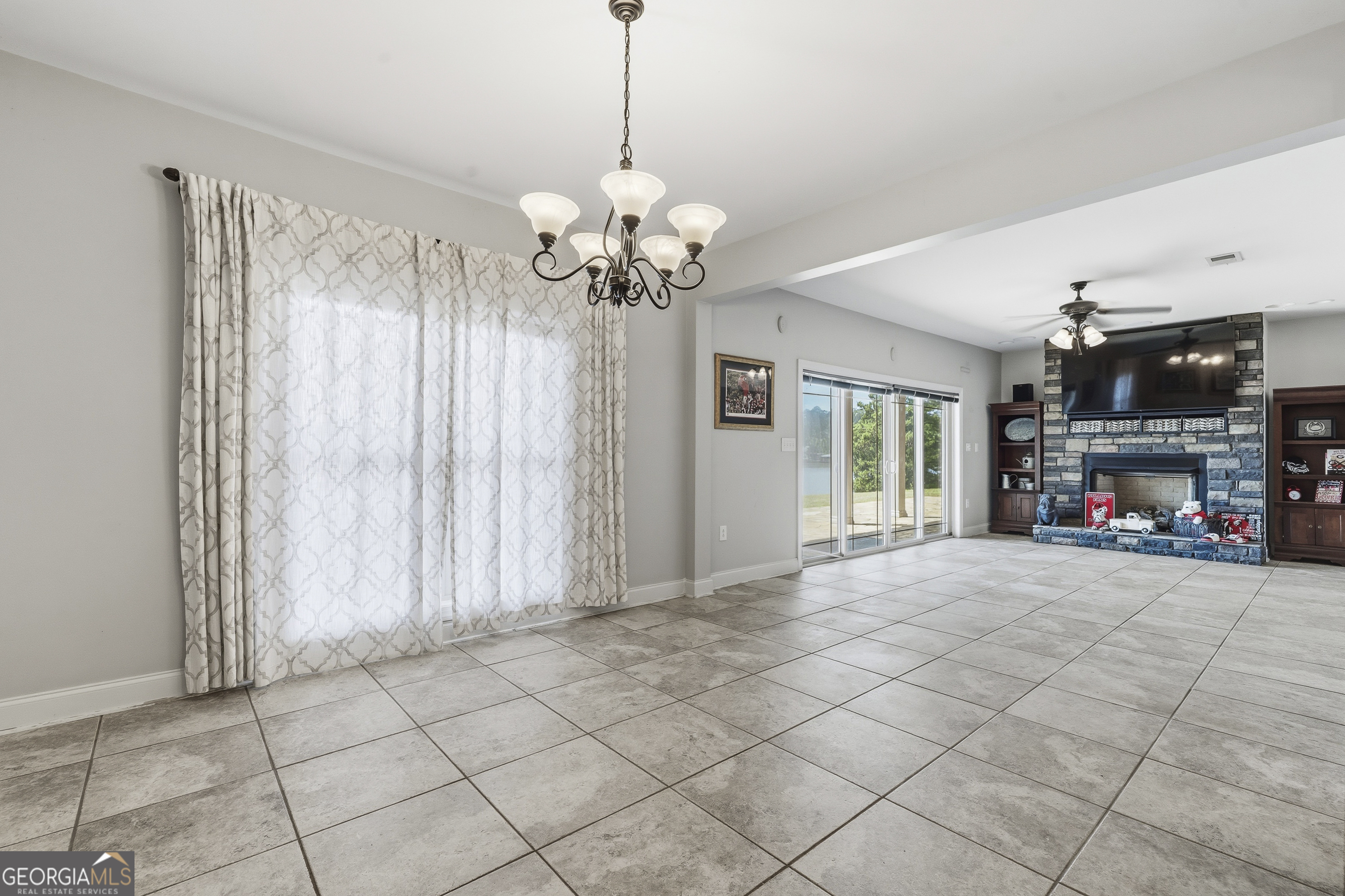 1038 Dennis Station Road Southwest Eatonton, GA 31024 - Photo 66 of 72 a view of a livingroom with a fireplace a ceiling fan and windows