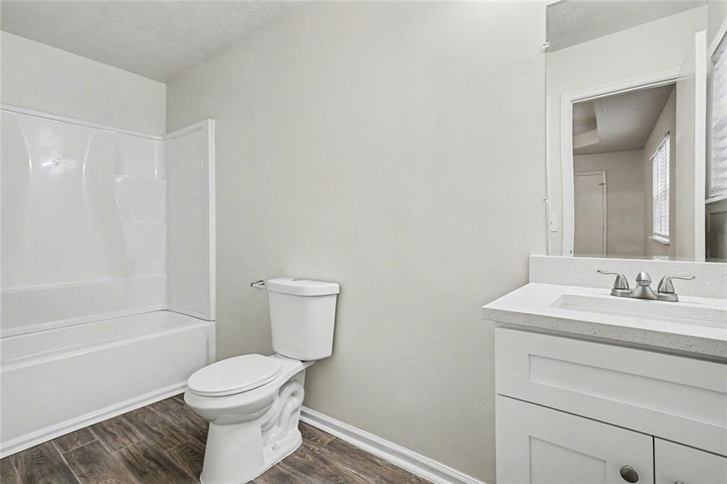 5571 Tunbridge Wells Road Lithonia, GA 30058 - Photo 14 of 23 a bathroom with a toilet a sink a mirror and a bathtub
