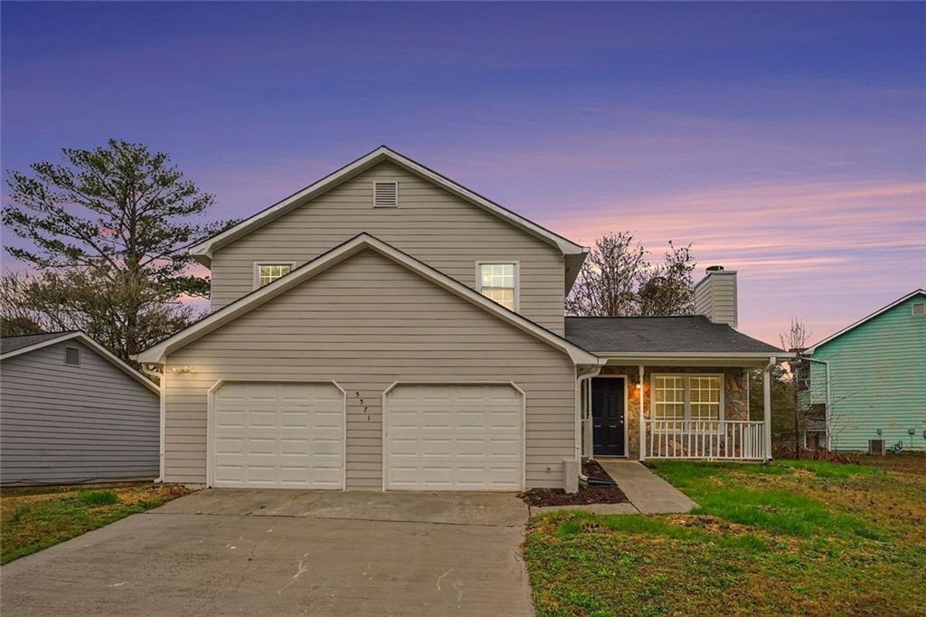 5571 Tunbridge Wells Road Lithonia, GA 30058 - Photo 2 of 23 a front view of a house with a yard and garage