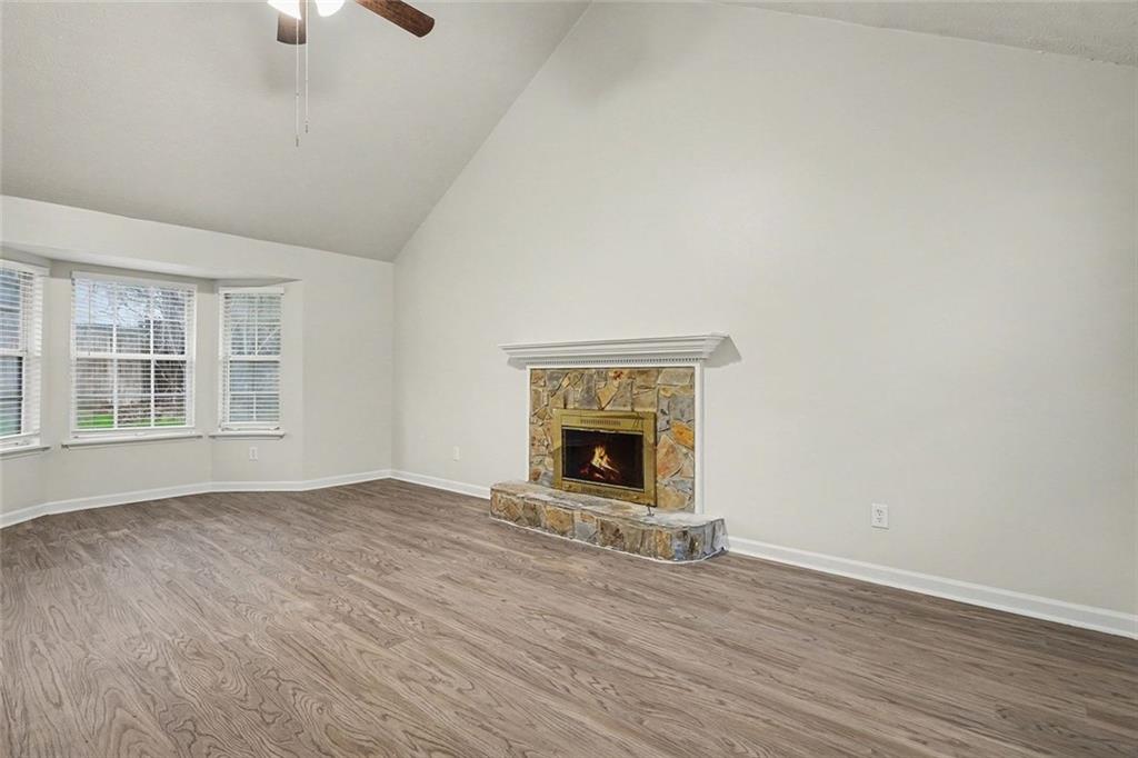 5571 Tunbridge Wells Road Lithonia, GA 30058 - Photo 5 of 23 wooden floor fireplace and windows in an empty room