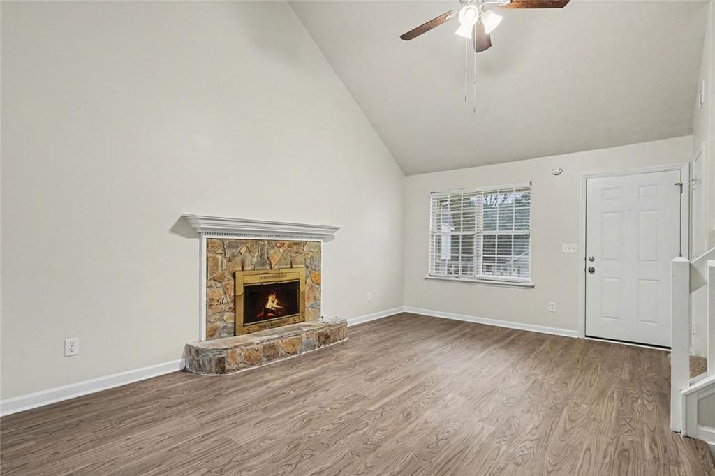5571 Tunbridge Wells Road Lithonia, GA 30058 - Photo 6 of 23 a view of an empty room with wooden floor fireplace and a window