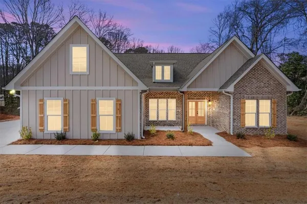 a view of a house with a yard and potted plants