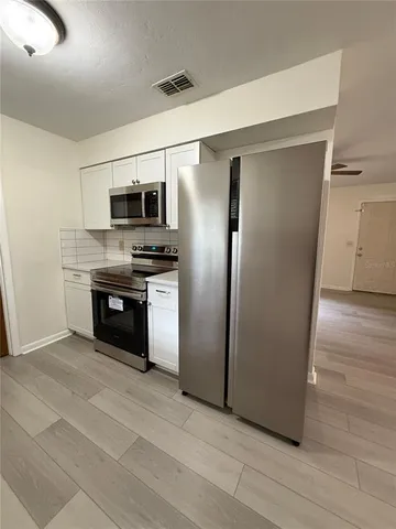 a kitchen with stainless steel appliances a refrigerator and a stove top oven