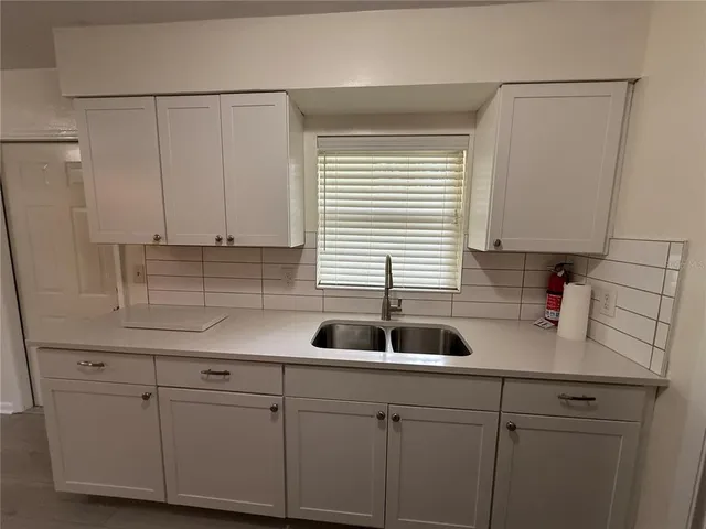 a kitchen with white cabinets a sink and dishwasher