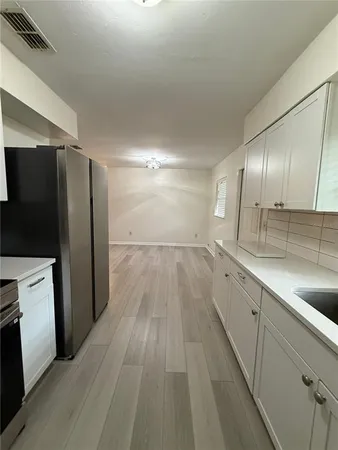 a view of a kitchen with a sink and refrigerator