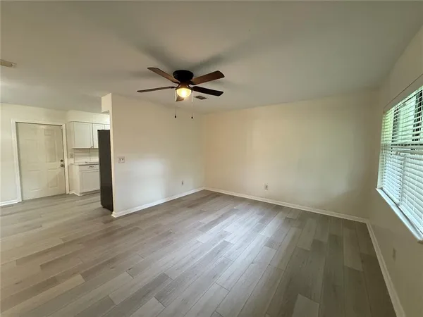 an empty room with wooden floor and windows