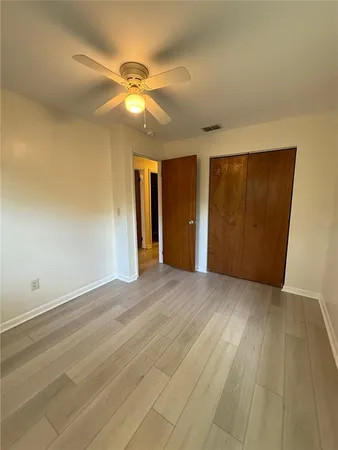 an empty room with closet and fan