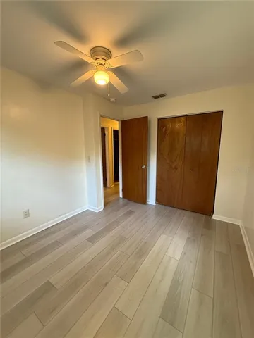 an empty room with closet and fan