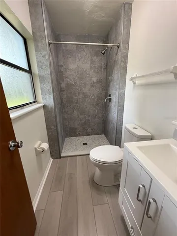 a white toilet sitting next to a bathroom sink and a shower