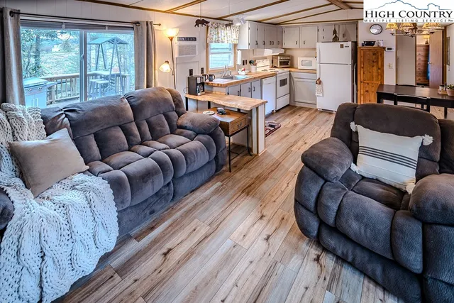 a kitchen with a refrigerator a stove top oven a sink and wooden floor