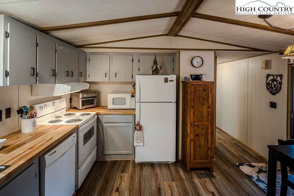 135 Mountain Ivy Lane Boone, NC 28607 - Photo 12 of 29 a kitchen with a refrigerator a stove top oven a sink and wooden floor