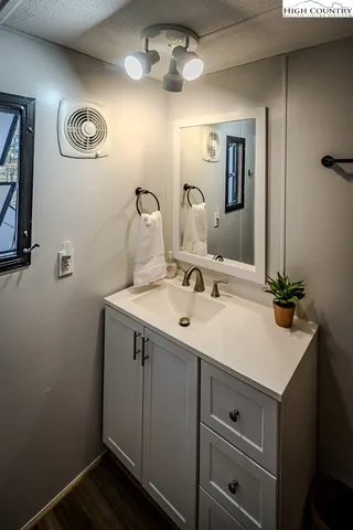 a view of a hallway with wooden floor and a rug