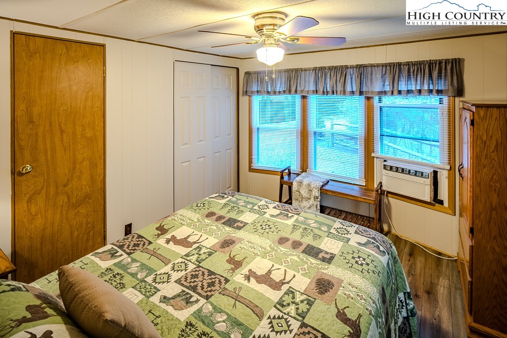 135 Mountain Ivy Lane Boone, NC 28607 - Photo 24 of 29 a bedroom with a bed a dresser and a chandelier