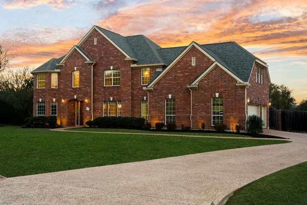 a view of a house next to a lake with a big yard