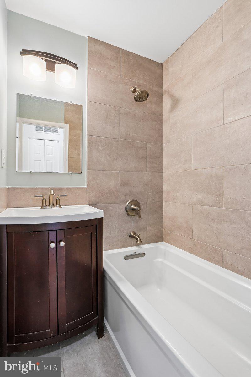 76 Timber Rock Road Gaithersburg, MD 20878 - Photo 34 of 51 a bathroom with a double vanity sink a mirror and a bathtub