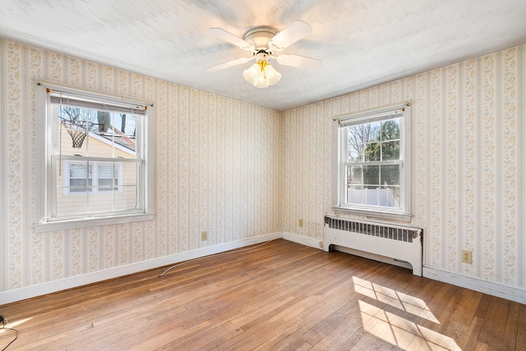 14 Hillside Road Braintree, MA 02184 - Photo 19 of 42 an empty room with wooden floor chandelier fan and windows
