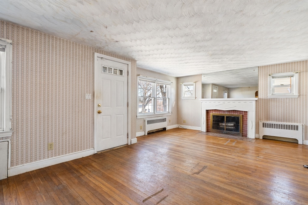 14 Hillside Road Braintree, MA 02184 - Photo 5 of 42 an empty room with fireplace wooden floor and windows