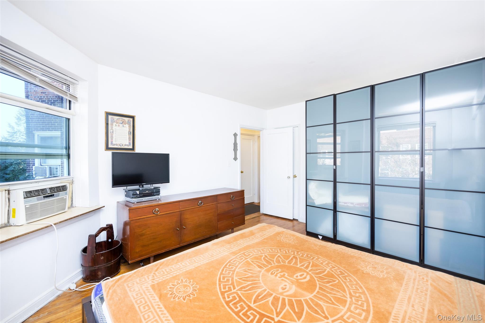 141-24 78th Road, Unit 3A Queens, NY 11367 - Photo 11 of 15 a bedroom with a bed and a flat screen tv
