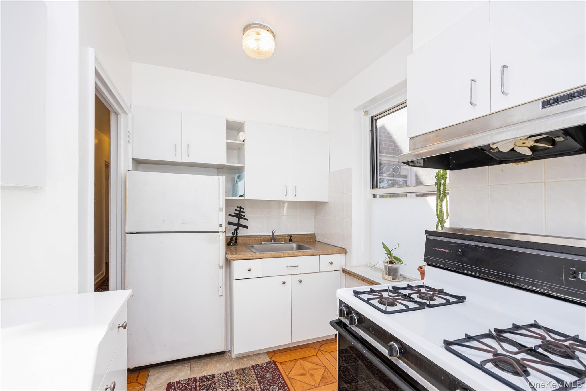 141-24 78th Road, Unit 3A Queens, NY 11367 - Photo 8 of 15 a kitchen with a refrigerator and a stove