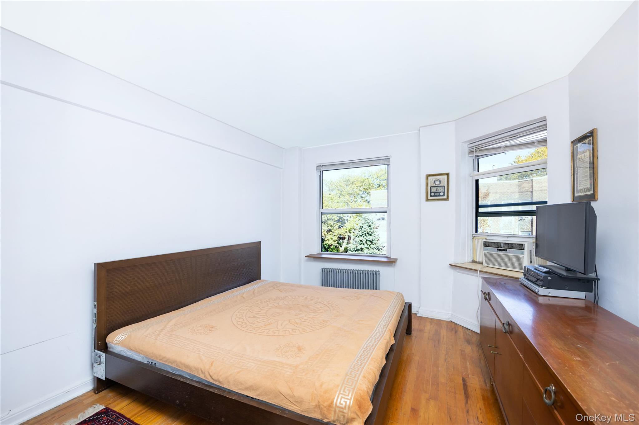 141-24 78th Road, Unit 3A Queens, NY 11367 - Photo 10 of 15 a bed sitting in a bedroom next to a window