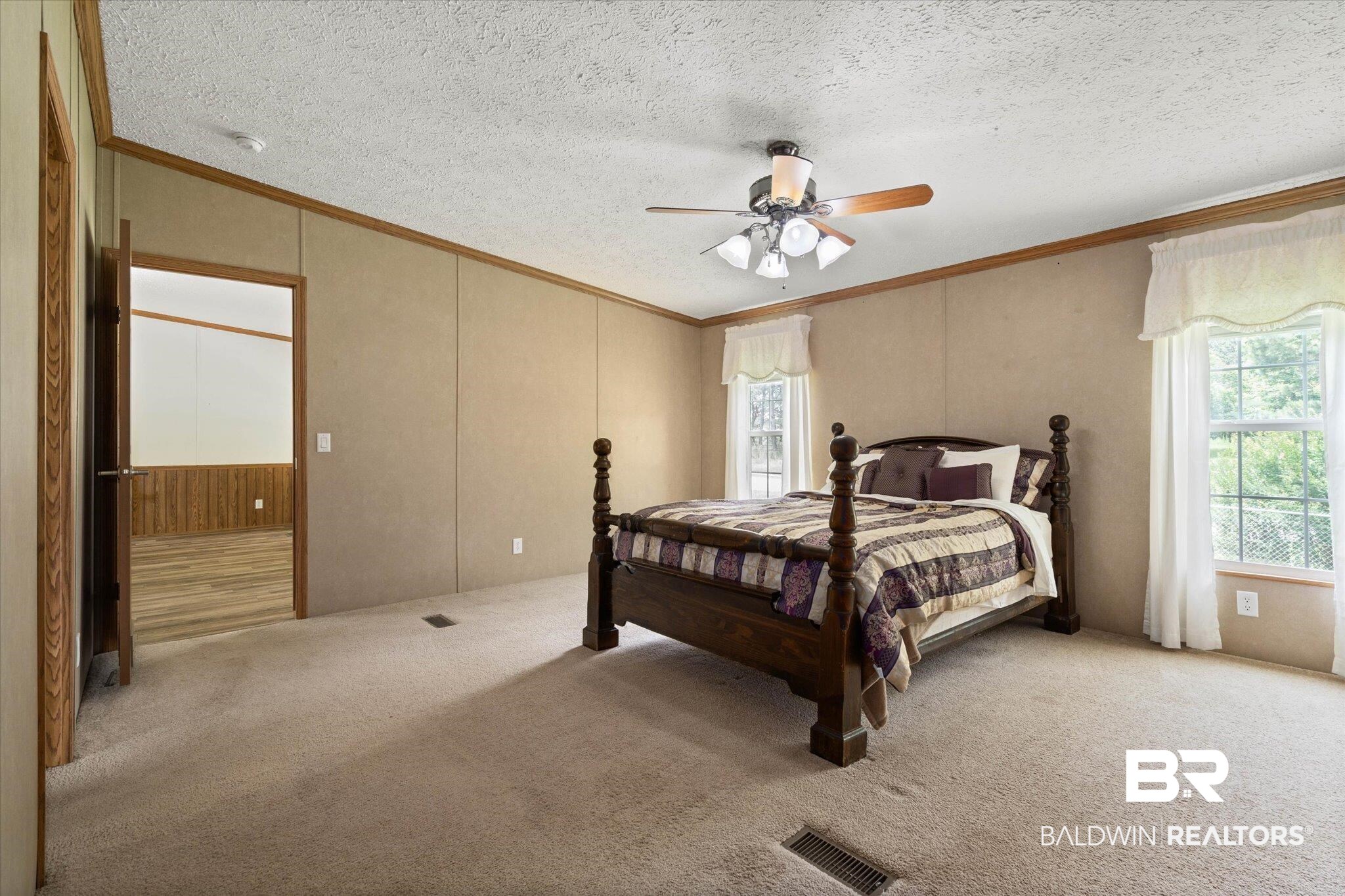 9335 Nathan Jordan Road Millry, AL 36558 - Photo 12 of 20 Carpeted bedroom featuring ornamental molding, a ceiling fan, and a textured ceiling