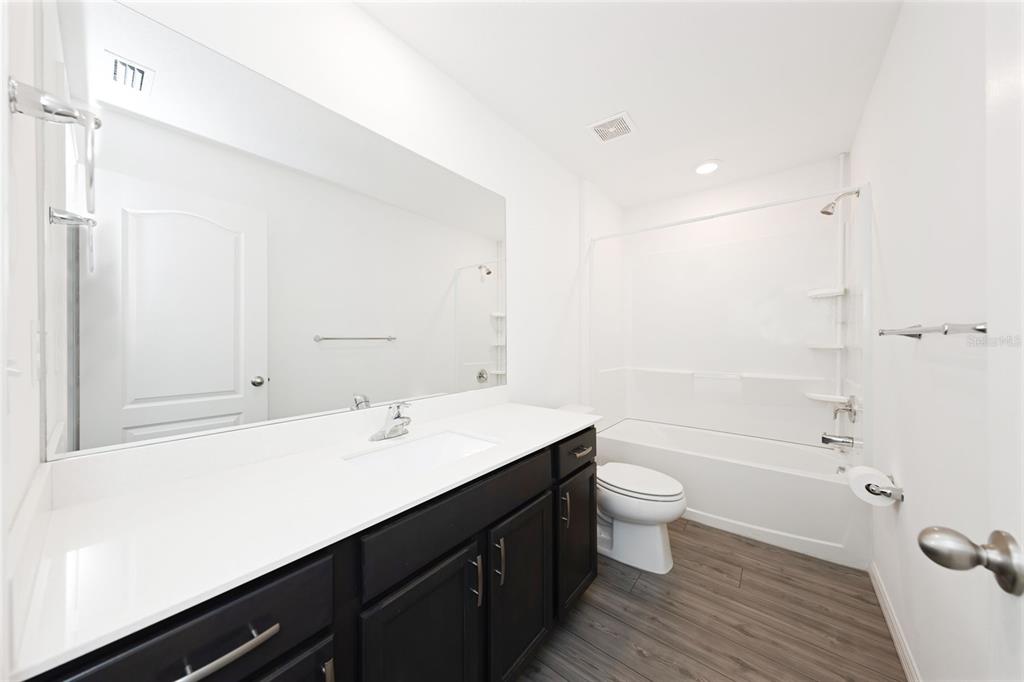 8646 Pinetop Ridge Lane Brooksville, FL 34613 - Photo 25 of 76 a bathroom with a sink a toilet a shower and a mirror