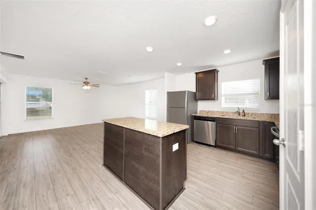 a kitchen with stainless steel appliances granite countertop a stove a refrigerator and a microwave