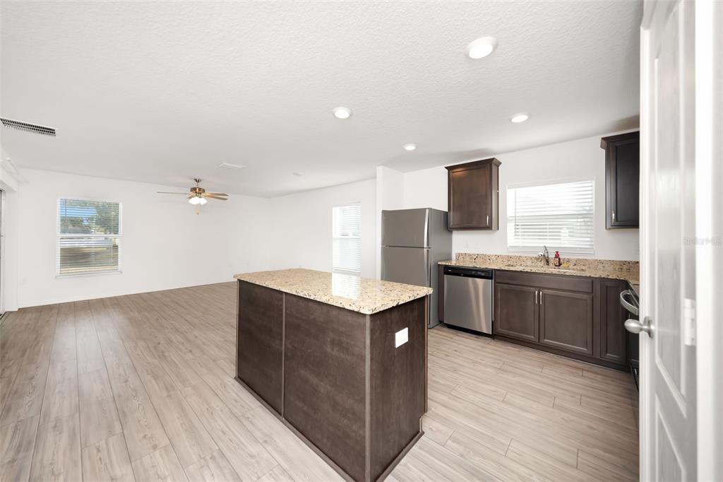 8646 Pinetop Ridge Lane Brooksville, FL 34613 - Photo 7 of 76 a kitchen with granite countertop a sink and a stove top oven