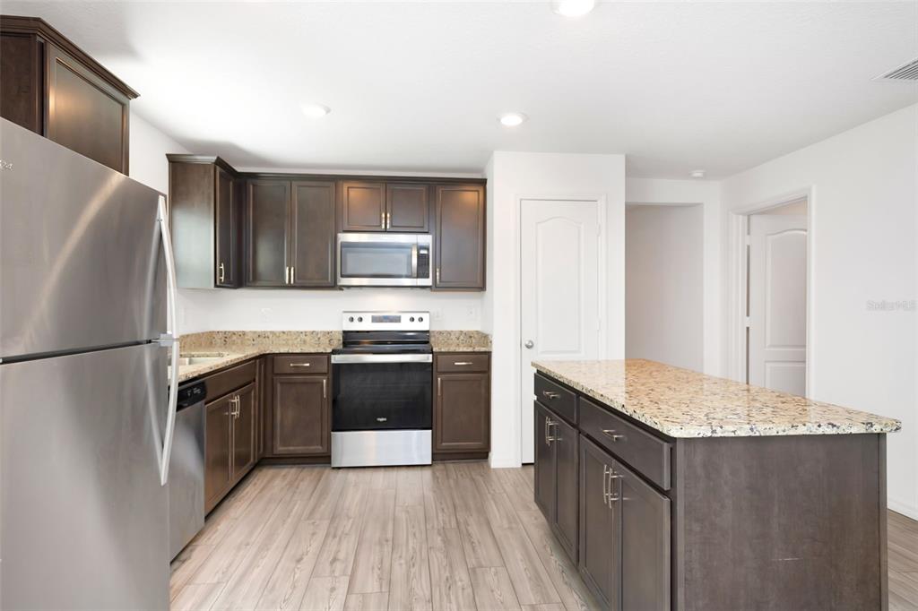 8646 Pinetop Ridge Lane Brooksville, FL 34613 - Photo 8 of 76 a kitchen with granite countertop a refrigerator stove and sink