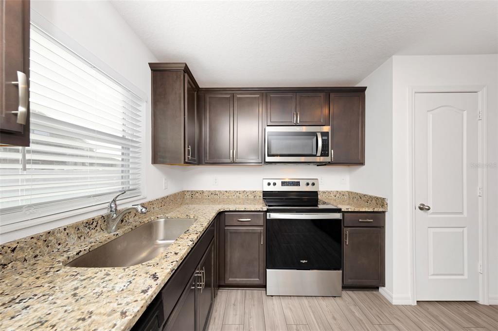 8646 Pinetop Ridge Lane Brooksville, FL 34613 - Photo 10 of 76 a kitchen with a sink stove and microwave