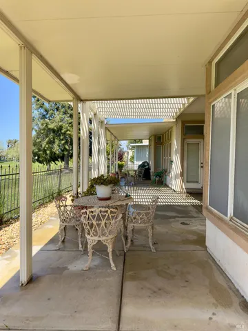 a view of a patio with table and chairs and potted plants
