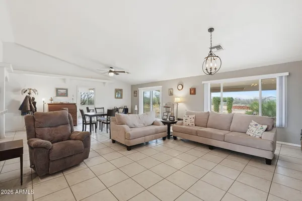 a living room with furniture kitchen view and a wooden floor