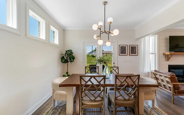 a view of a dining room with furniture a chandelier and wooden floor
