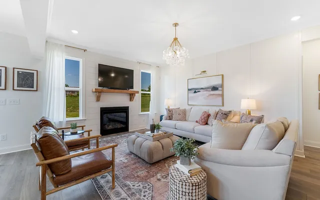 a living room with furniture a flat screen tv and a fireplace