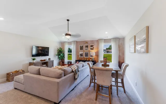 a living room with furniture a flat screen tv and a window