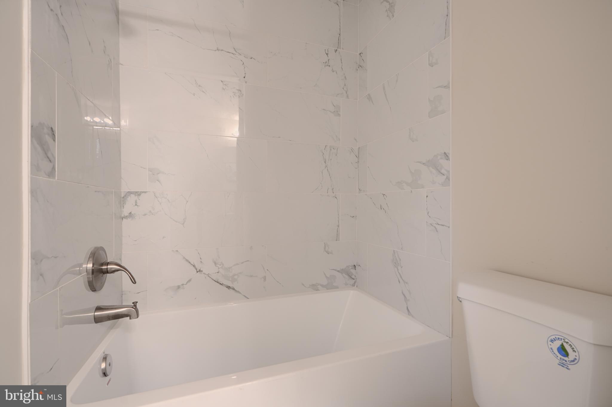 3308 Walbrook Avenue Baltimore, MD 21216 - Photo 18 of 32 a white bath tub sitting next to a white sink and vanity