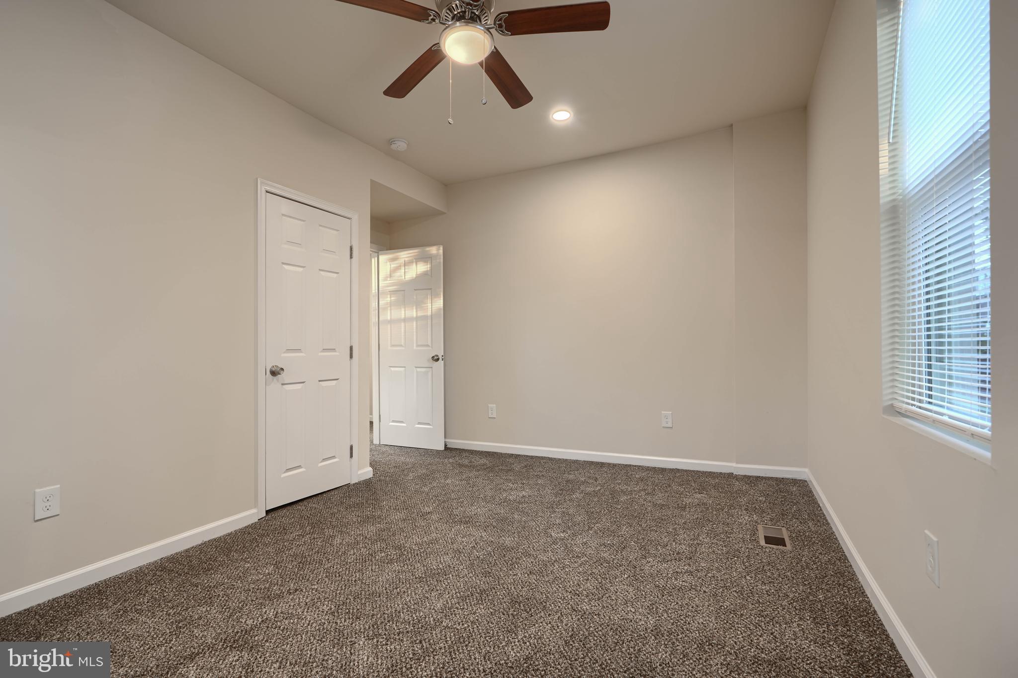 3308 Walbrook Avenue Baltimore, MD 21216 - Photo 19 of 32 an empty room with a ceiling fan and window