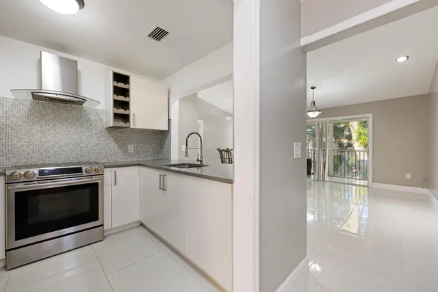a kitchen with granite countertop a sink stainless steel appliances and cabinets