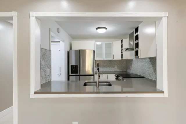 a view of kitchen with a sink and a refrigerator