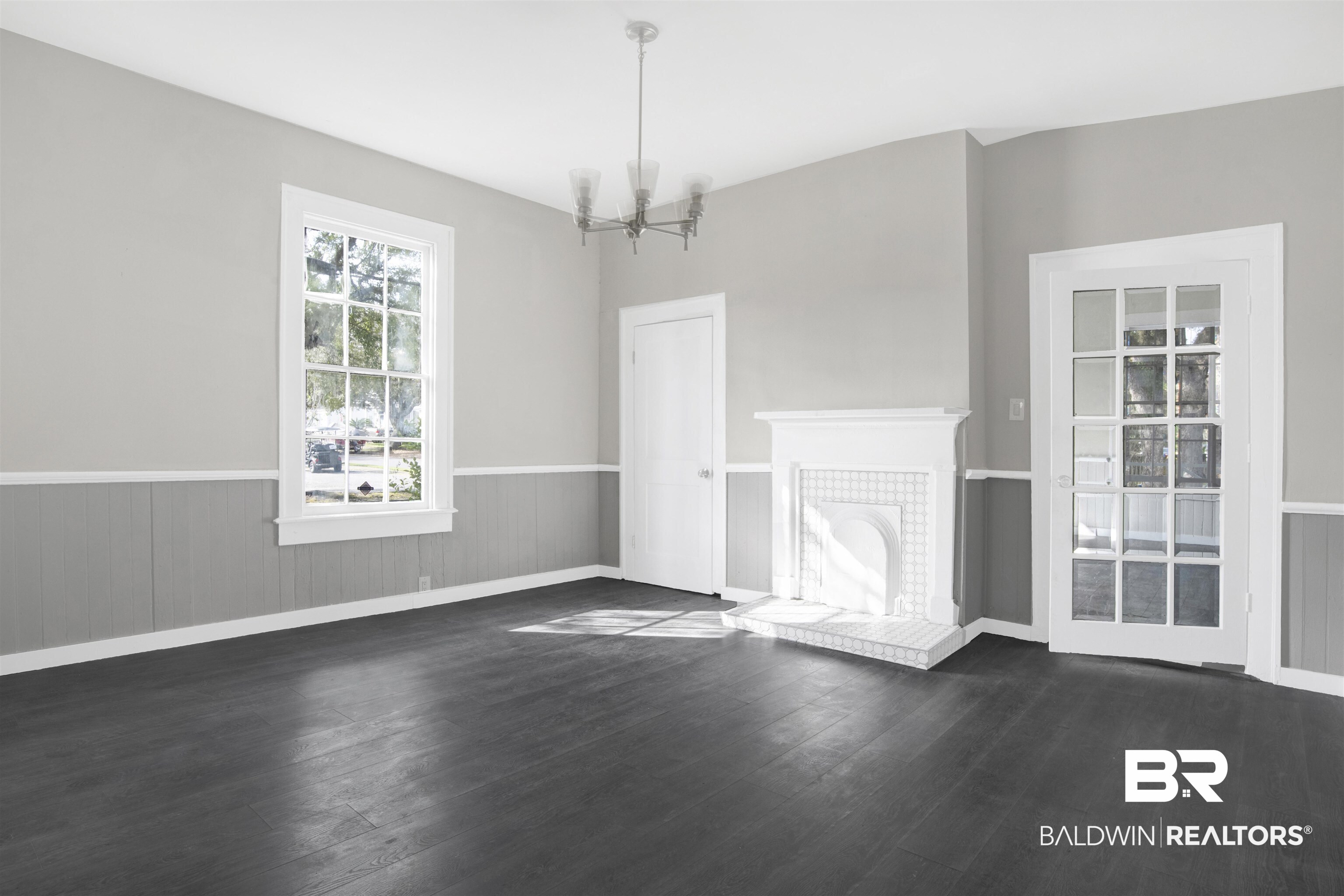 1063 Selma Street Mobile, AL 36604 - Photo 9 of 32 Unfurnished dining area with a wainscoted wall, dark wood finished floors, suspended lighting, and a tile fireplace