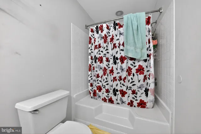 a bathroom with a toilet and a shower curtain