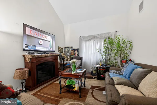 a living room with furniture a fireplace and a flat screen tv