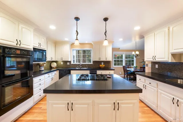 a view of a dining room with furniture a chandelier and wooden floor